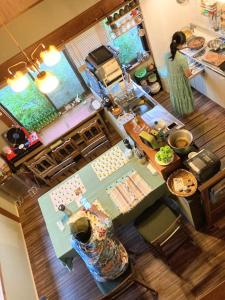 an overhead view of a kitchen with a woman preparing food at 静かに過ごす古民家ステイ Staying quietly in renovated house in Takashima