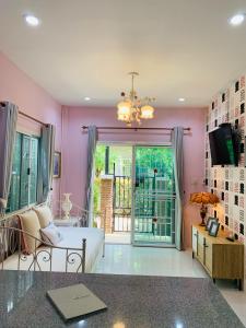 Ban MuangにあるIris Homestayのピンクの部屋(ベッド1台、ガラスのスライドドア付)