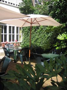 a patio with an umbrella and tables and chairs at Eco Hotel Mundaka in Mundaka