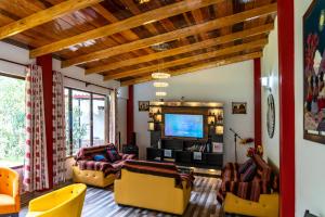 a living room with couches and a flat screen tv at Hotel Tierra Inka Sacred Valley in Ollantaytambo