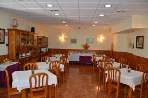 a dining room with white tables and wooden chairs at San Marcos in Huesca