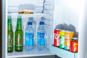 a refrigerator filled with bottles and cans of soda at Shenzhen Castle Hotel in Longgang