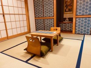 a room with a table and two chairs in it at Ostay Numabukuro Hotel Apartment in Tokyo