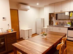 a kitchen with a wooden table in the middle of it at Ostay Numabukuro Hotel Apartment in Tokyo