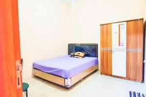 A bed or beds in a room at Green Kanca Syariah Guest House Mitra RedDoorz