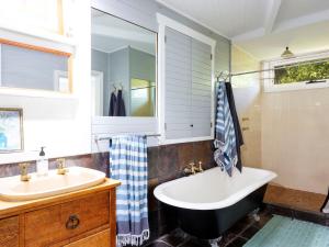 a bathroom with a tub and a sink at Garden Cottage in Tea Gardens +18 photos