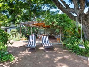 two chairs and a table in a yard at Garden Cottage in Tea Gardens