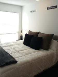 a white bed with black pillows in a bedroom at Village Center 2 bedroom Condo in Big White