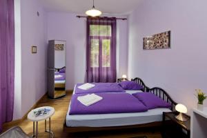 sypialnia z fioletowym łóżkiem i lustrem w obiekcie Unione w mieście Gordevio
