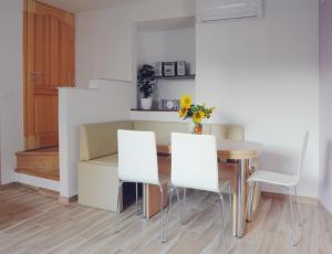 a dining room with a table and white chairs at APARTMA KMETIJA ROVAN in Vrhpolje