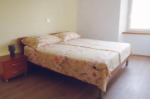 a bed in a room with a dresser and a bed sidx sidx at APARTMA KMETIJA ROVAN in Vrhpolje