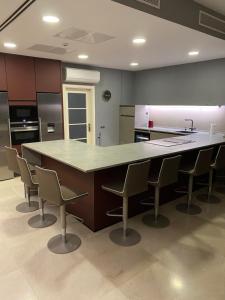 a large kitchen with a large counter and chairs at Villas Opal Anfi Tauro in Mogán