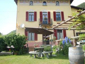 una casa con tavolo e ombrellone in cortile di Unione a Gordevio