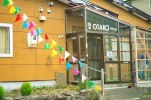 um edifício com uma bandeira colorida à sua frente em Otaru Village - Vacation STAY 84438 em Otaru