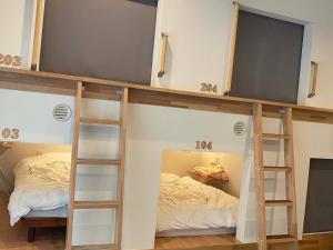 弘前市にあるホステル弘前の二段ベッド2台、テレビが備わる客室です。