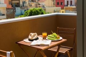 a table with a plate of food on a balcony at Thallos The Boutique in Chania +42 photos