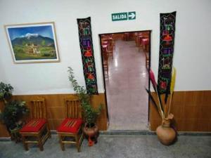 a building with a hallway with chairs and a sign at Hotel Frontera in La Quiaca