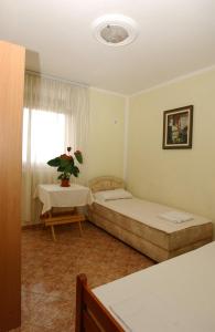 a room with two beds and a table and a window at Rooms & Apartments Anka in Bar