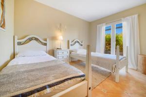 sypialnia z dwoma łóżkami i oknem w obiekcie Villa Turo del Sol w mieście Cala Murada +23 zdjęcia