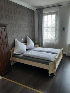 een slaapkamer met een groot bed met witte lakens en kussens bij CT-Apartments in Kerken
