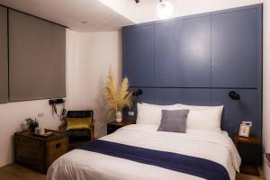 a bedroom with a large bed with a blue headboard at Jiufen 35 in Jiufen