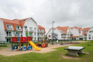 a park with a playground with a slide and a table at ibis Styles Nieuwpoort in Nieuwpoort