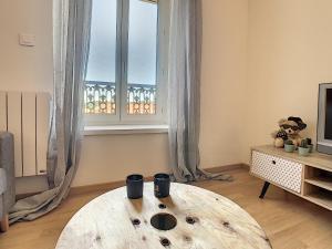 un soggiorno con tavolo in legno di fronte a una finestra di Bourgoin-Jallieu Appartement les Augustins a Bourgoin