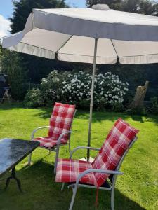 dwa krzesła i stół z parasolem w obiekcie CT-Apartments w mieście Kerken