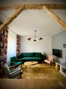 sala de estar con sofá verde y mesa en Rynek_28, en Ciężkowice