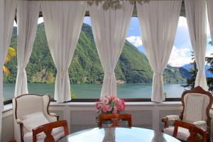 una camera con una grande finestra con vista sul lago di Barony Le Pergole holiday apartments Lugano a Lugano