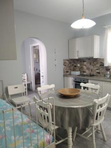 cocina y comedor con mesa y sillas en Myconian Cottage, en Ano Mera