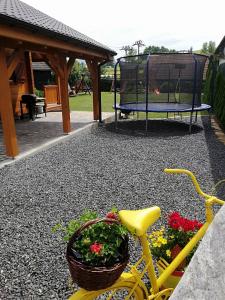 a yellow bike with a basket of flowers next to a playground at Chata Kaprík in Liptovský Mikuláš