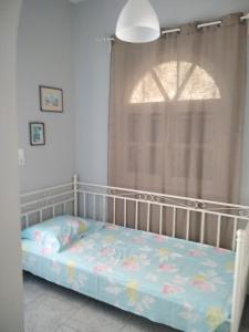 a bed in a room with a window at Myconian Cottage in Ano Mera