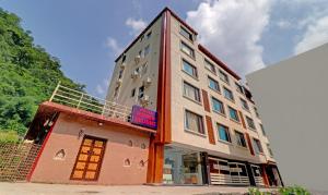瑞诗凯诗Hotel Hidden Delight Rishikesh的前面有一间商店的高楼