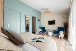 a bedroom with a bed and two blue chairs at Une Escale à Pornic chambres d'hôtes 4 épis in Pornic