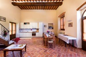 a living room with a table and a kitchen at Casale Vacanze Il Granaio in Cortona