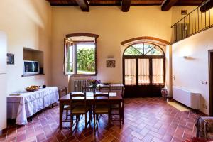 a living room with a table and chairs in it at Casale Vacanze Il Granaio in Cortona