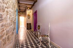 um corredor com 2 cadeiras e piso em azulejo em Attiki Hotel in Ilha de Rhodes