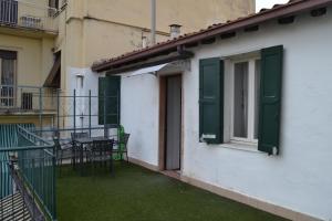 balcón con persianas verdes, mesa y sillas en Gabrielli Rooms et Apartments Sant Antonio alloggio 4 M0230914084, en Verona