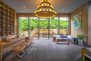a large lobby with a large window and a chandelier at Sunsuri Phuket - SHA Plus in Nai Harn Beach