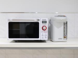 a microwave and a toaster on a kitchen counter at CHISUN BUDGET Kanazawa Ekimae in Kanazawa