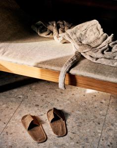 a pair of shoes laying on the floor next to a bed at Karl August - a Neighborhood Hotel in Nuremberg