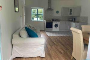 a living room with a white couch and a kitchen at DUNGARVAN,beautiful cottage near Comeragh Mountains in Dalligan Bridge +32 photos
