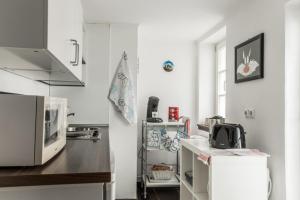 a kitchen with white walls and a counter with a microwave at Pension Harmony in Marburg an der Lahn