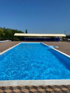 a large blue swimming pool with a building in the background at Hotel Kryve Ozero in Kryve Ozero
