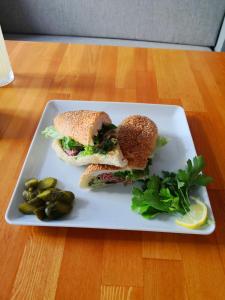 un sándwich y pepinillos en un plato en una mesa en Yuva Butik, en Eskisehir