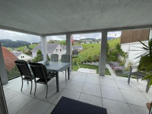 a dining room with a table and chairs on a balcony at Hälmli in Heiden