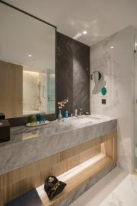 
a bathroom with a sink, mirror, and bathtub at Guangzhou Baiyun Hotel in Guangzhou
