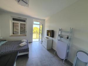 a room with a bed and a bathroom with a television at Villa Adagio Apartments in Sumartin