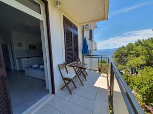 a balcony of a house with a table and chairs at Villa Adagio Apartments in Sumartin